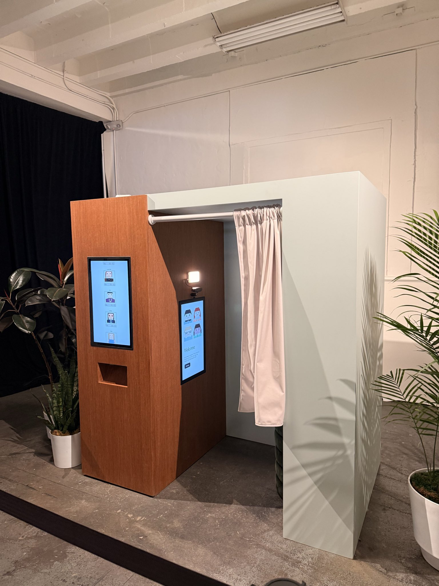Anthropic Claude photo booth setup with pixel art portraits on screens