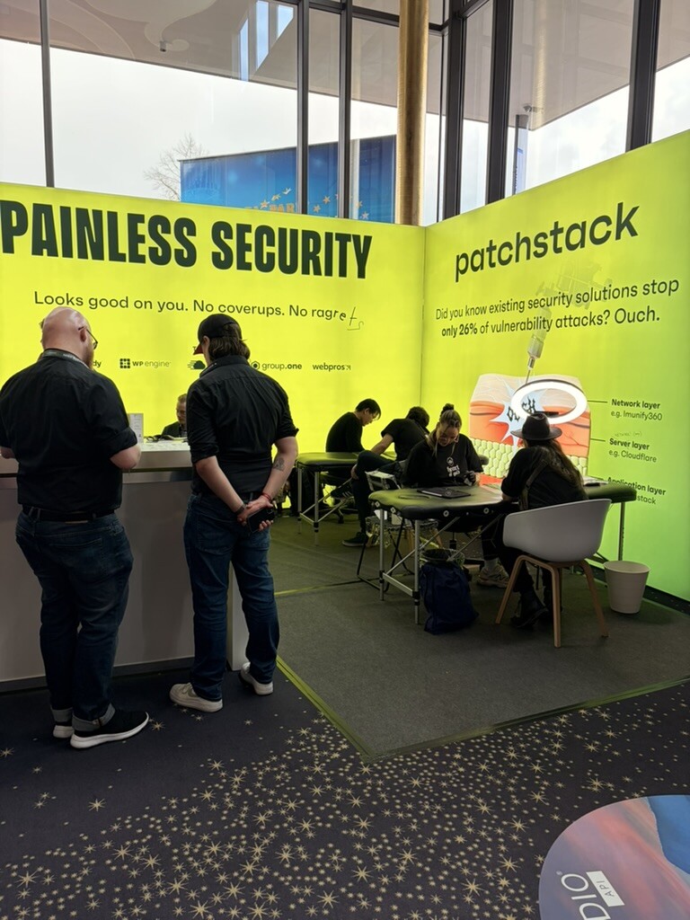 Patchstack booth with Painless Security slogan and free tattoo station